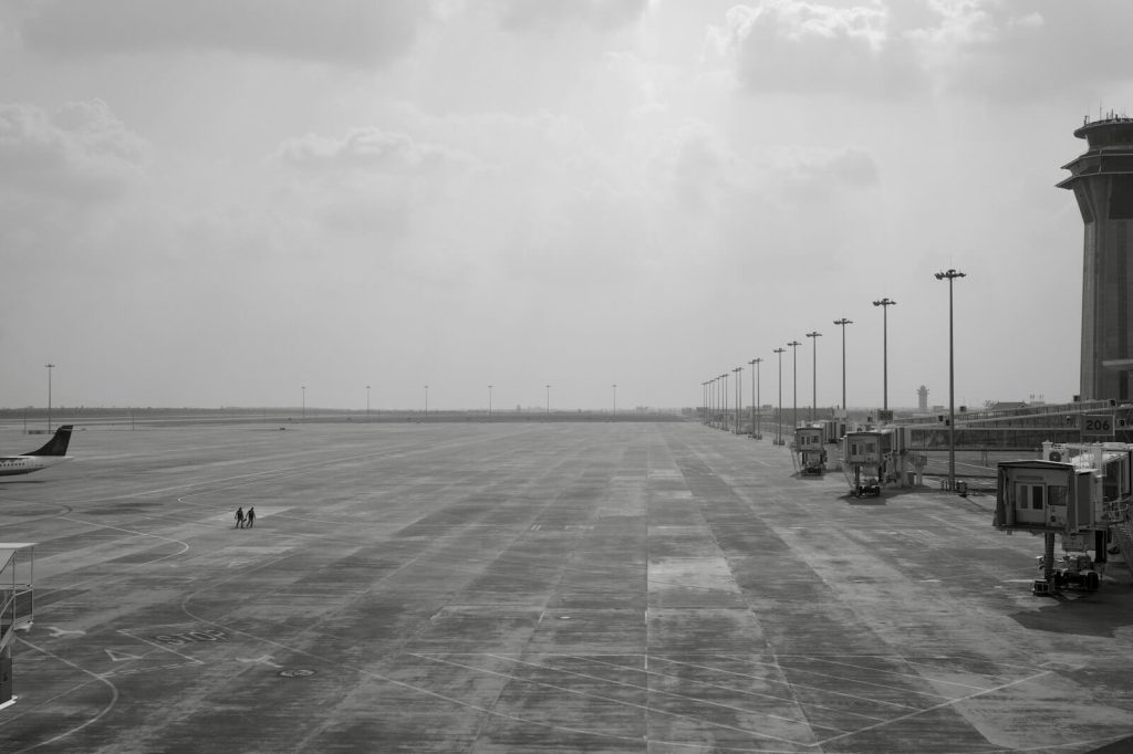 How to Earn British Airways Tier Points on American Airlines Flights 3 Wide view of an airport tarmac with jet bridges and control tower