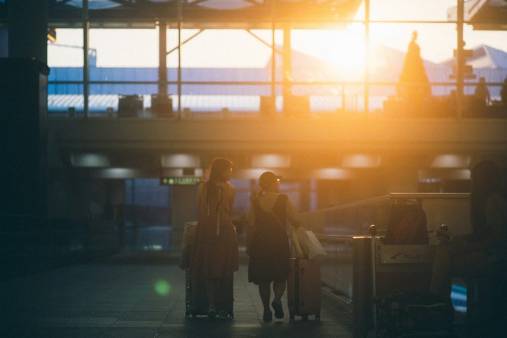 British Airways Household Account: How to Pool Avios With Family 3 Two travelers walking through an airport with luggage