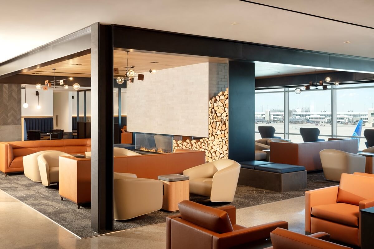 United Club lounge seating area with fireplace at Denver International Airport
