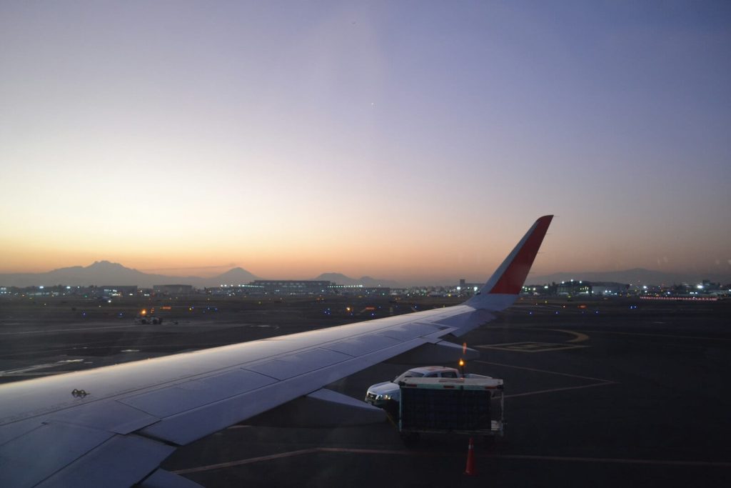 Alaska Atmos Rewards Summit Card Bonus: 80K Points & 25K-Point Global Companion Award 6 View of an airplane wing on the tarmac at sunset