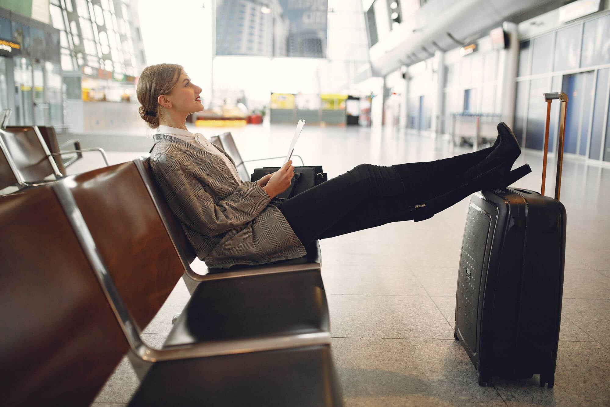AwardWallet Paywalls Expiration Alerts on Its Free Tier 3 Traveler relaxing in an airport terminal with luggage