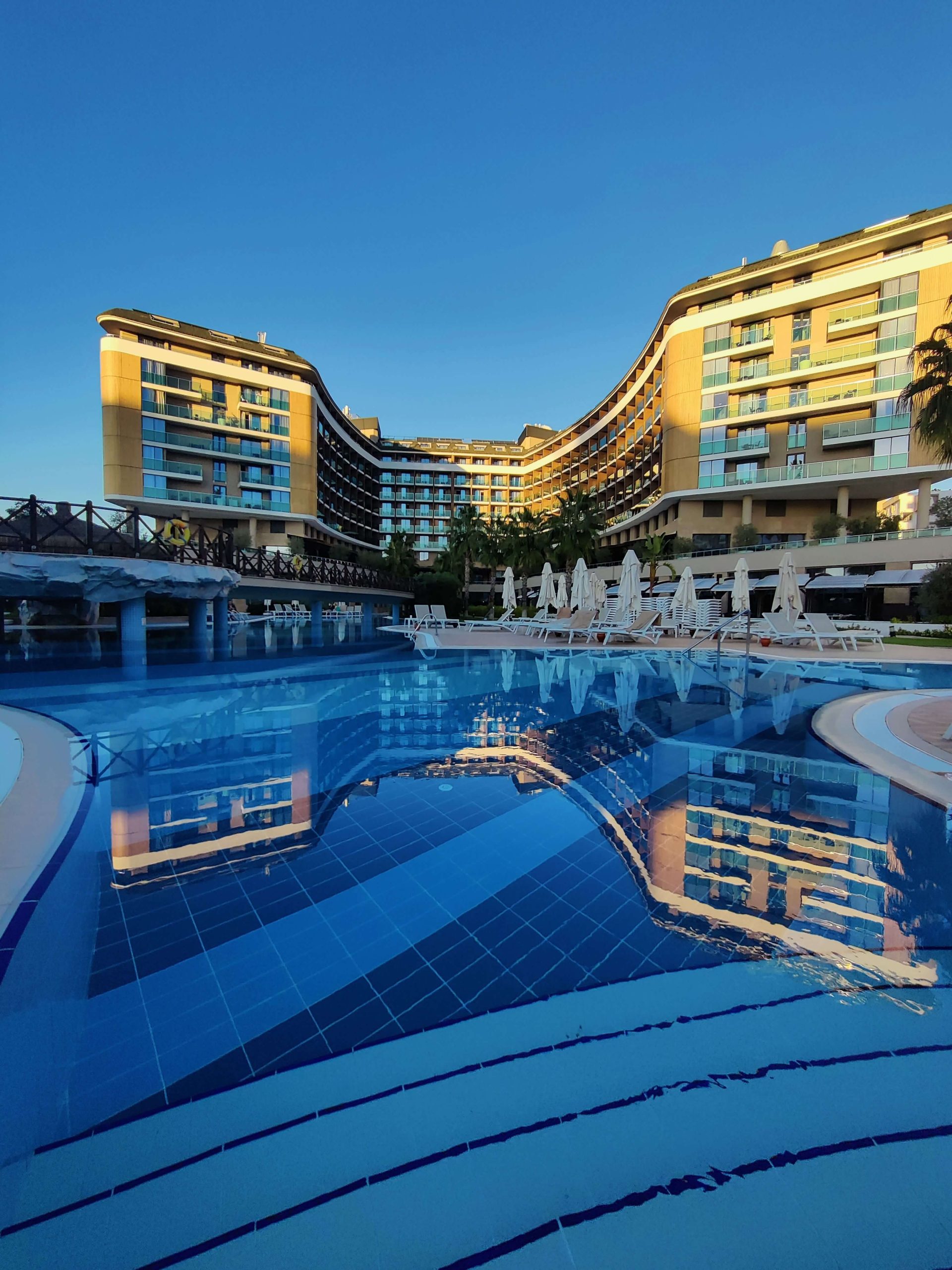 Resort hotel pool at dusk, representing Hilton Honors card benefits