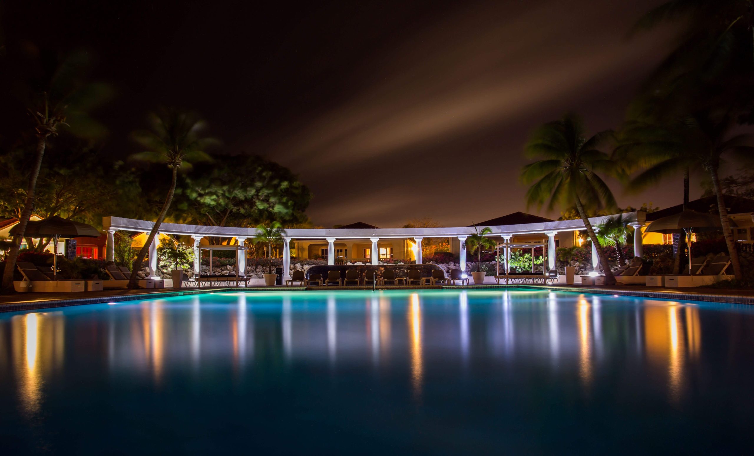 IHG One Rewards Premier Credit Card Review: Is the $150 Fee Worth It? 5 Resort pool and lounge area at night, the kind of IHG property where Anniversary Free Night certificates and F&B credits apply